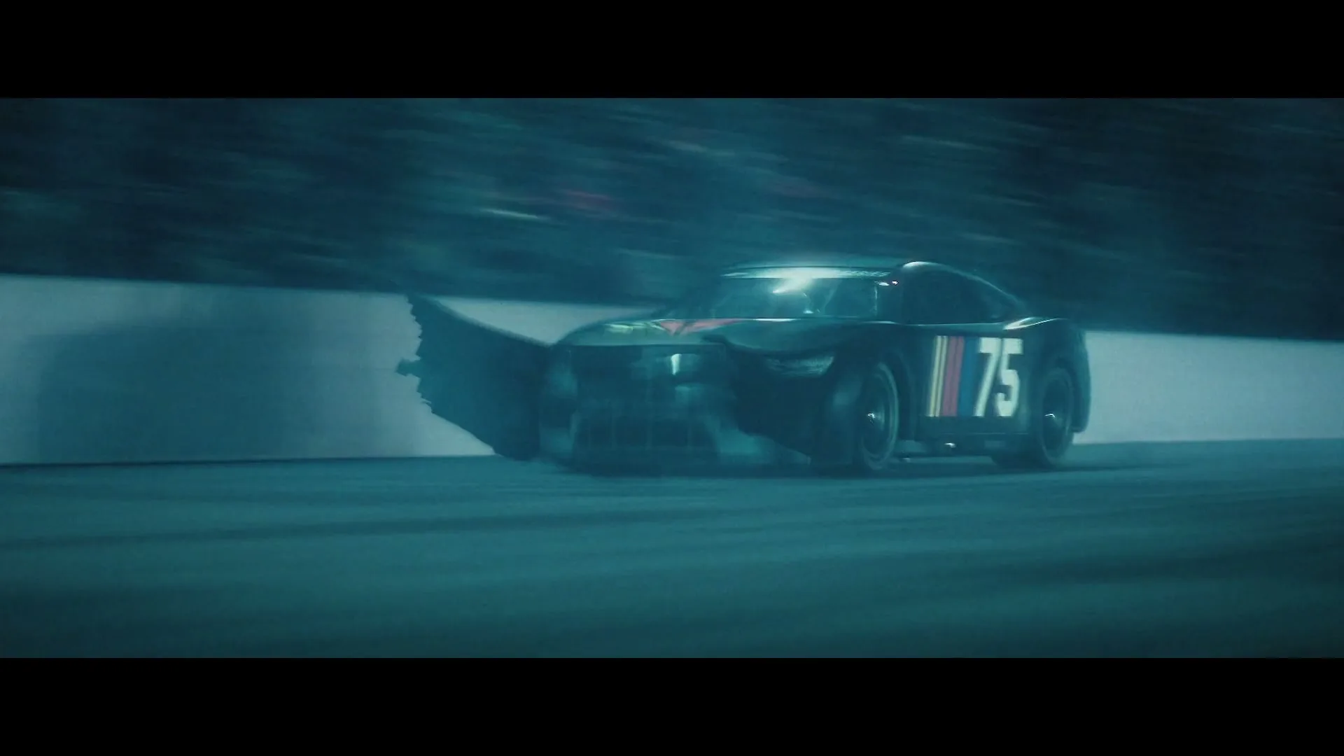 A black race car with the number 75 on its side speeds around a track, kicking up smoke and debris, at night.