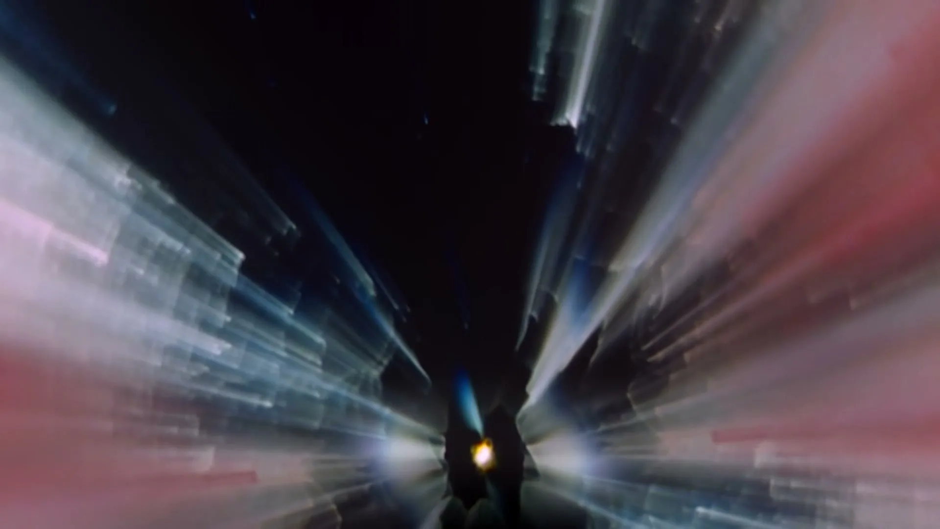 A dark, abstract tunnel with streaks of light in blue, white, and red, creating a sense of rapid movement through space.