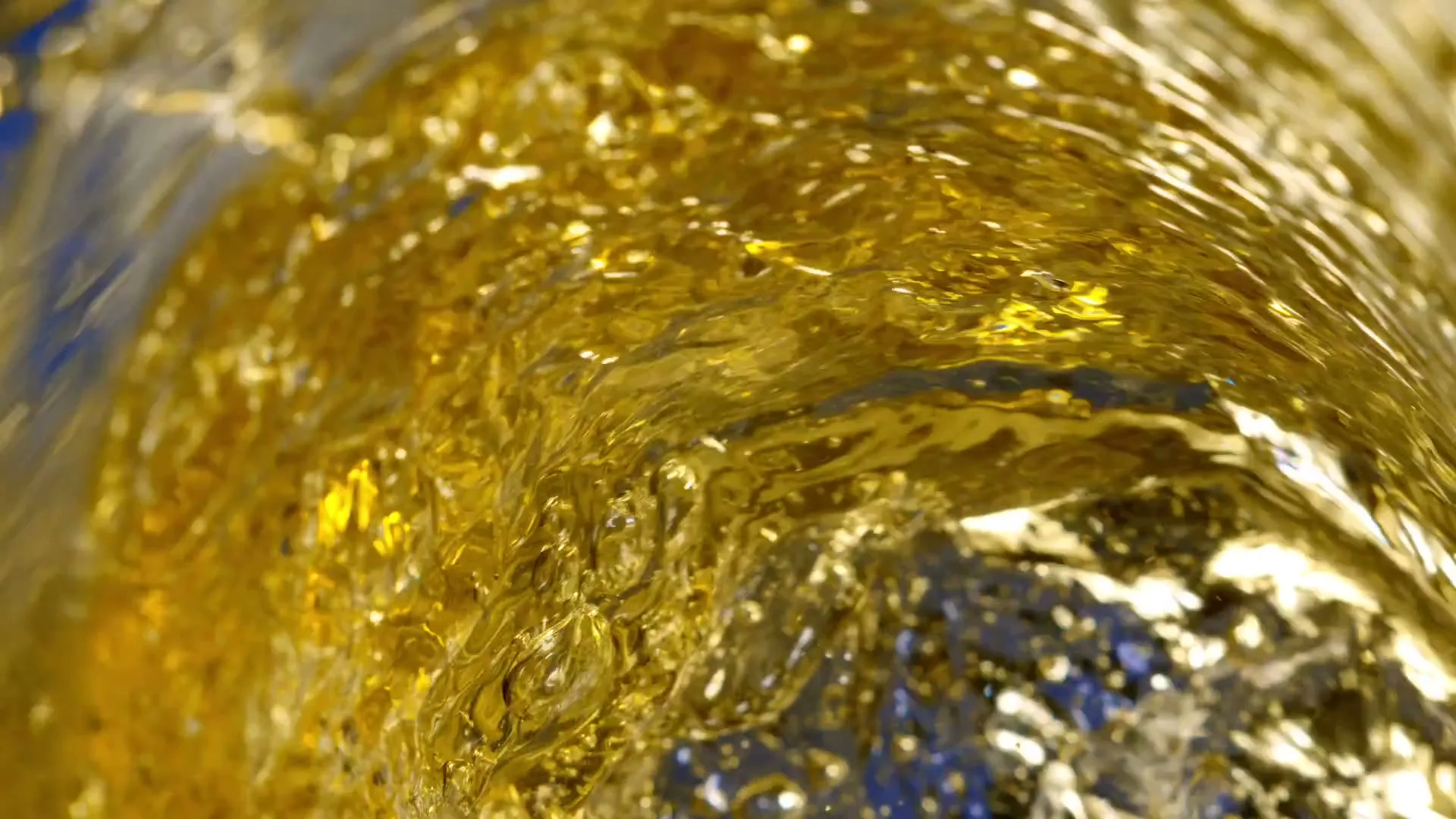 A close-up shot of golden liquid swirling and bubbling, creating a dynamic and refreshing visual effect.
