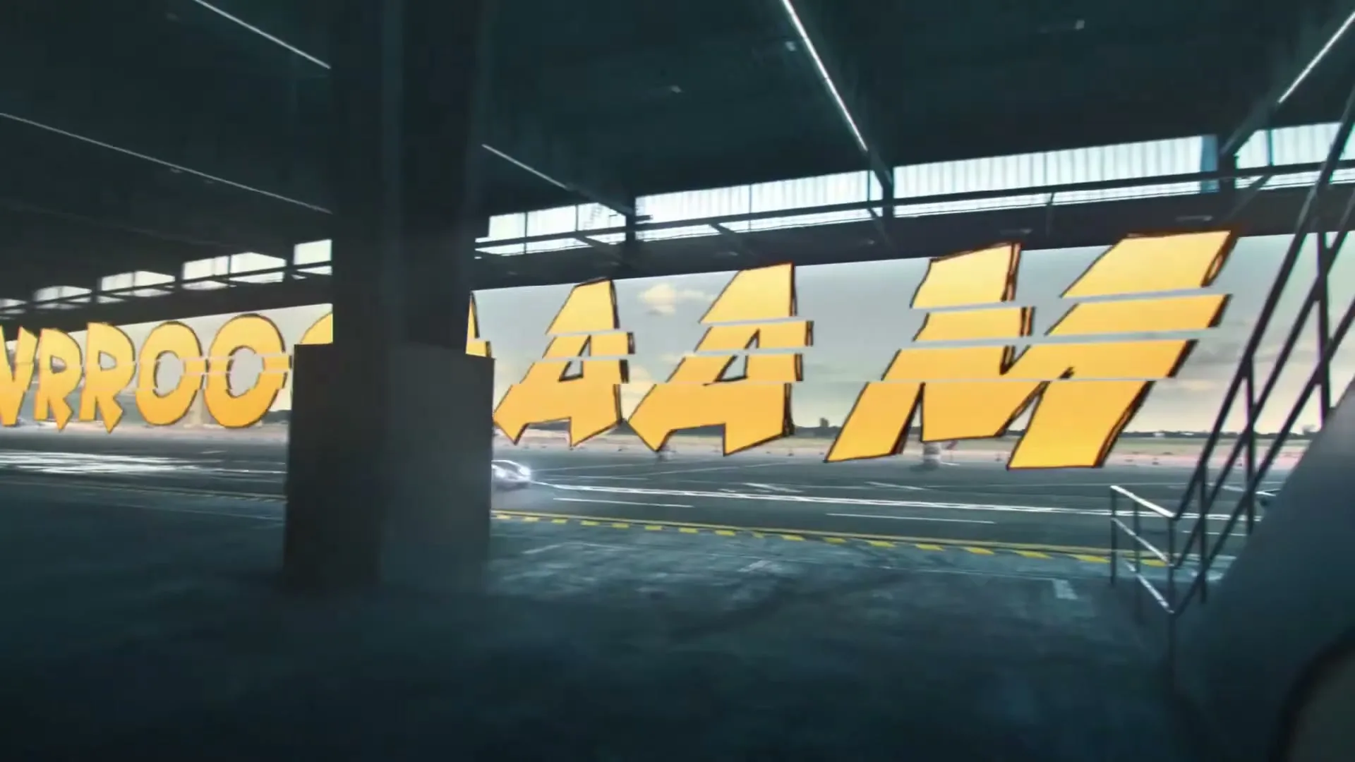 A race car speeds across an airfield runway, with large yellow on-screen text "VRROOOM" appearing and expanding across the frame.