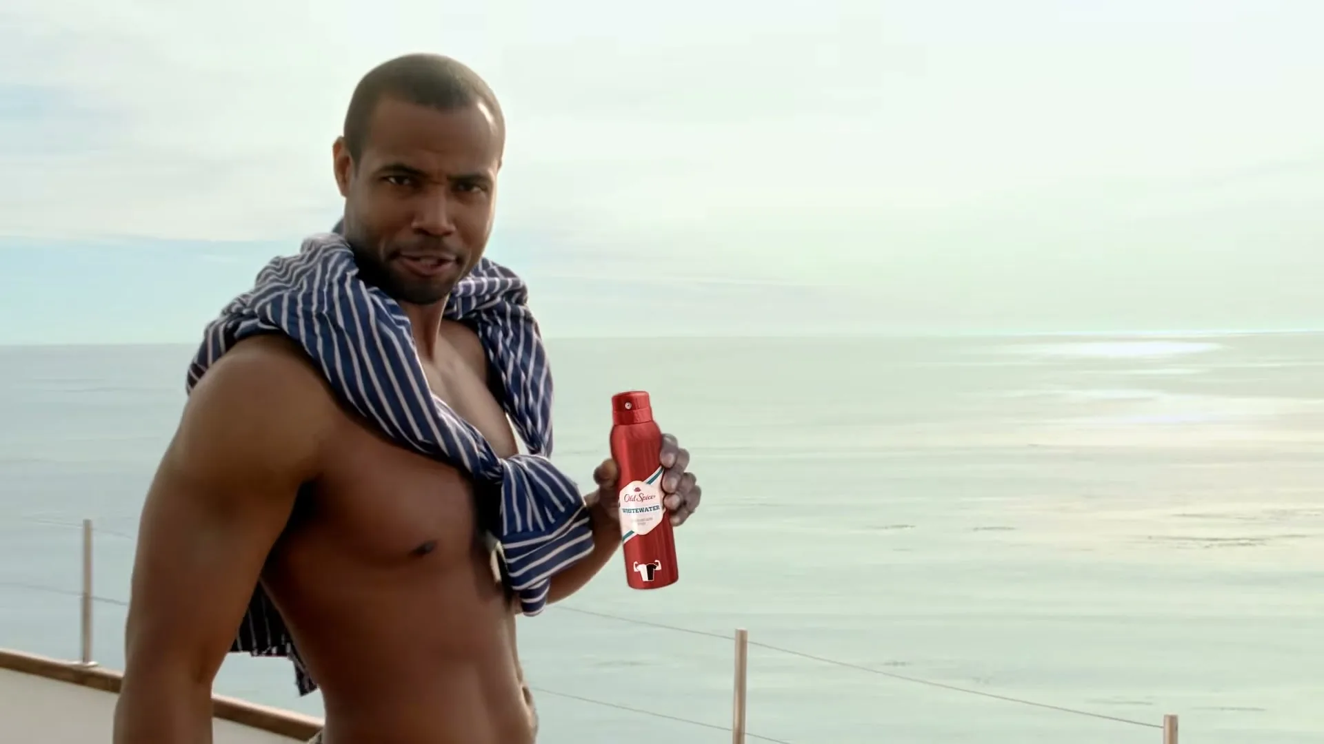 A muscular man in a towel transforms from a bathroom to a boat, then to a beach on a horse, all while holding Old Spice products.