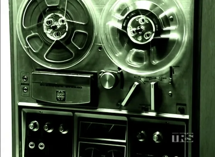 A man in a blue shirt is seen through a transparent reel-to-reel tape recorder, with text identifying him as a former co-worker.