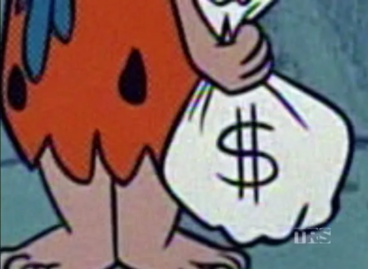 Fred Flintstone, an animated male character, holds a white money bag with a dollar sign on it, in a cartoon setting.