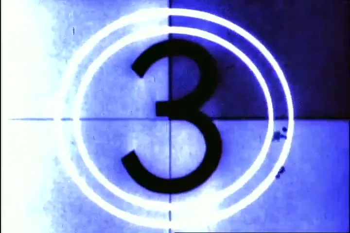 A vintage film countdown leader shows the number "3" in black against a distressed, blue-tinted background with a white circle appearing.