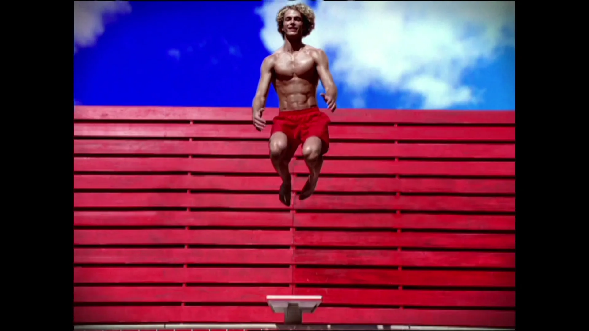 A shirtless man in red shorts jumps into a pool, then the Target bullseye logo appears on a red wall with blue sky.