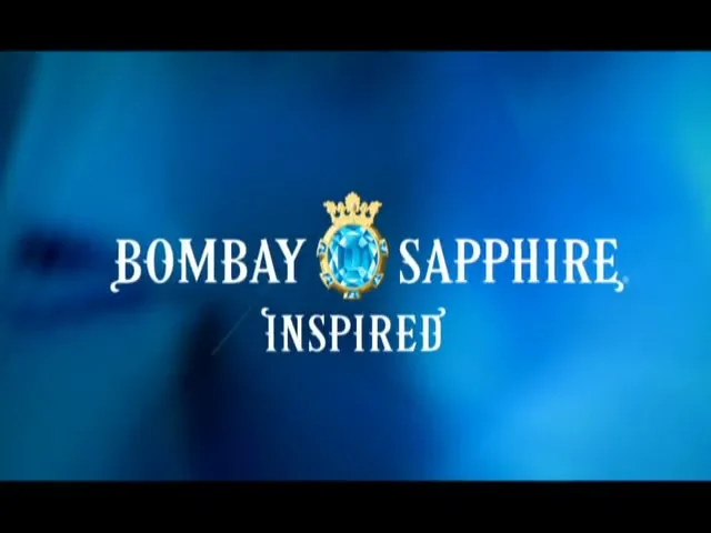 The Bombay Sapphire gin bottle is shown against a blue background, then the bottle fades to reveal the brand logo and tagline.