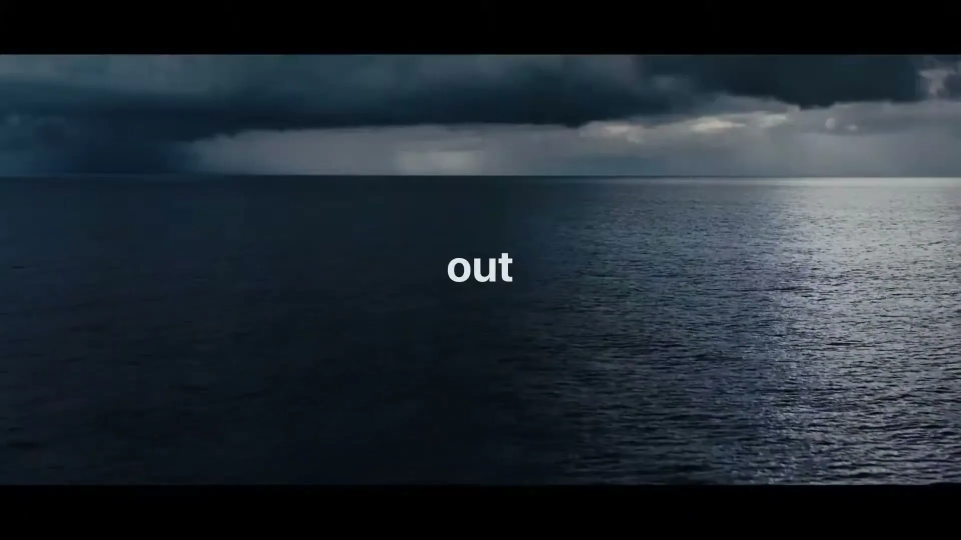 A wide shot of a dark, stormy ocean with a dramatic sky, as text appears on screen.