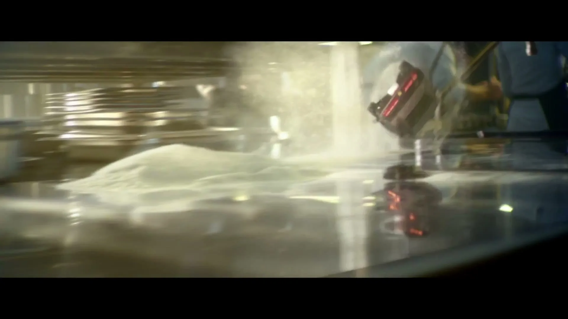 A miniature black muscle car drives on a reflective surface, crashes into a pile of white powder, and flips over in a kitchen.