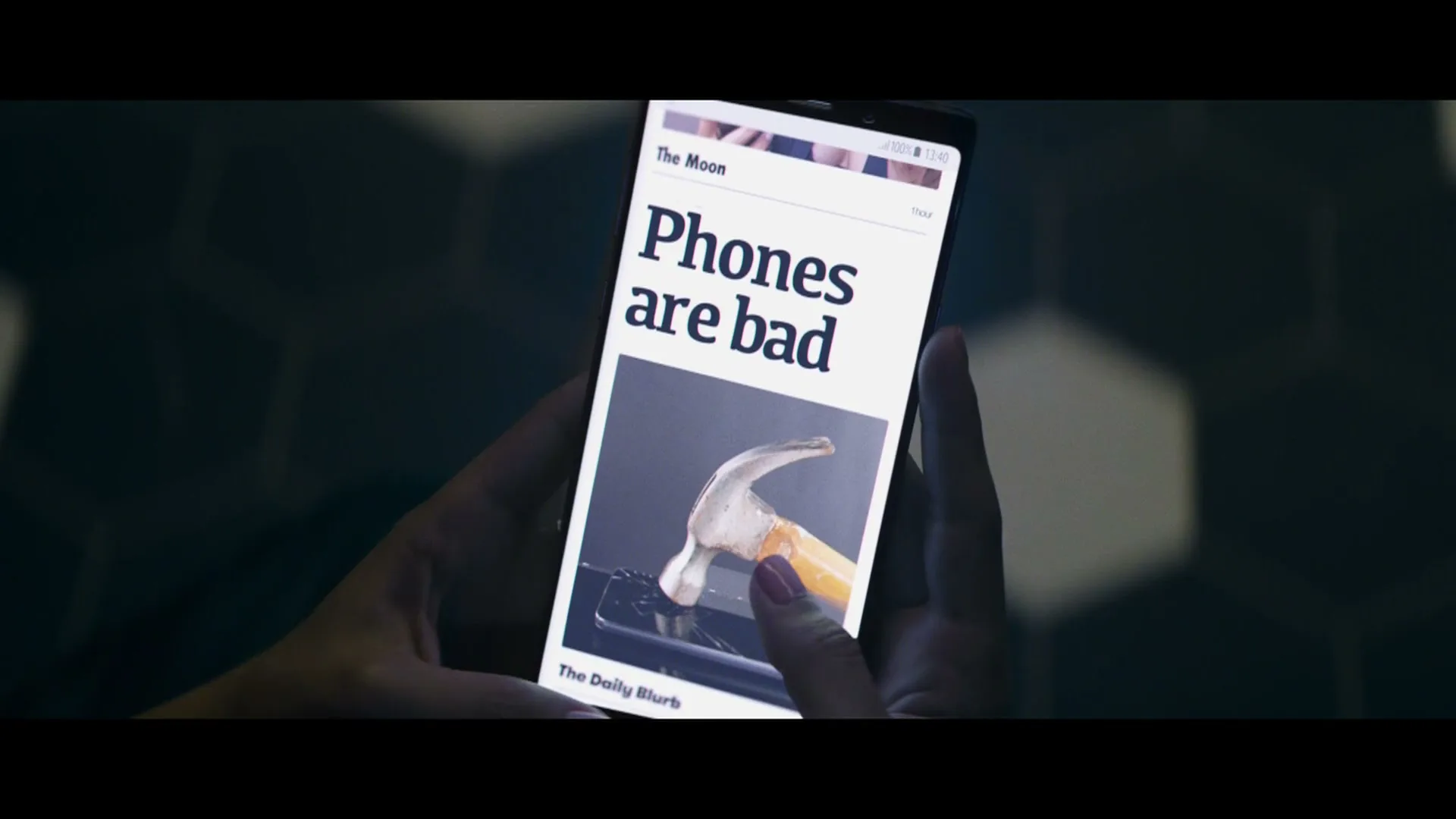 A person's hands hold a smartphone displaying a news article with the headline "Phones are bad" and an image of a hammer hitting a phone.