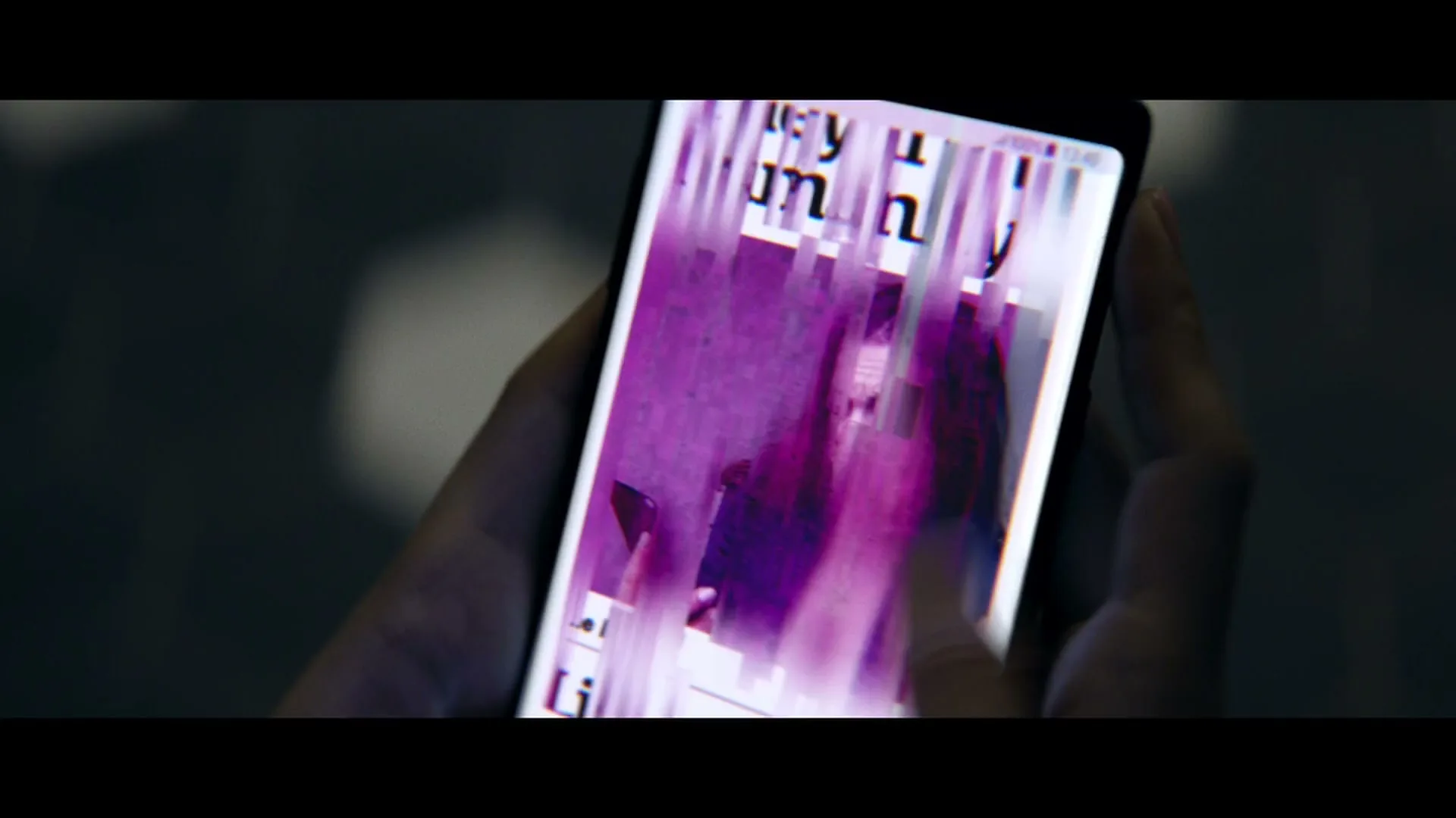 A person's hands hold a smartphone displaying a news article about a hammer, which then glitches into a purple screen before showing the Three network logo.