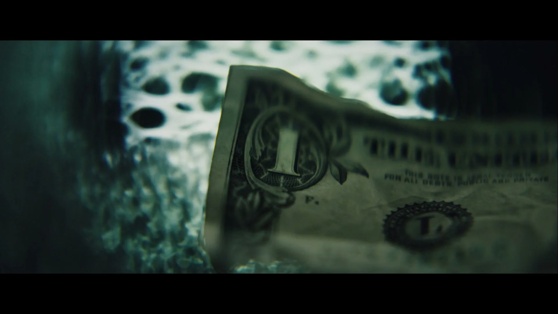 A close-up shot of a crumpled dollar bill with the number one visible, against a dark, textured background.