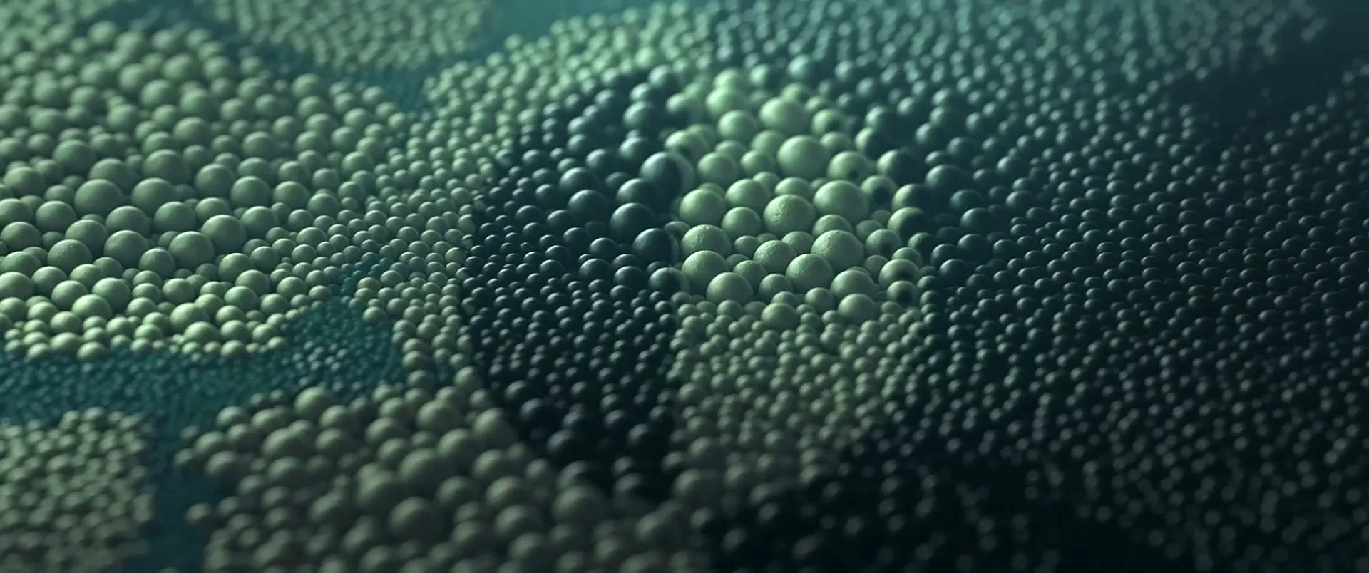 A close-up shot shows a dark green surface covered in small, light green spheres that ripple and move like a liquid.