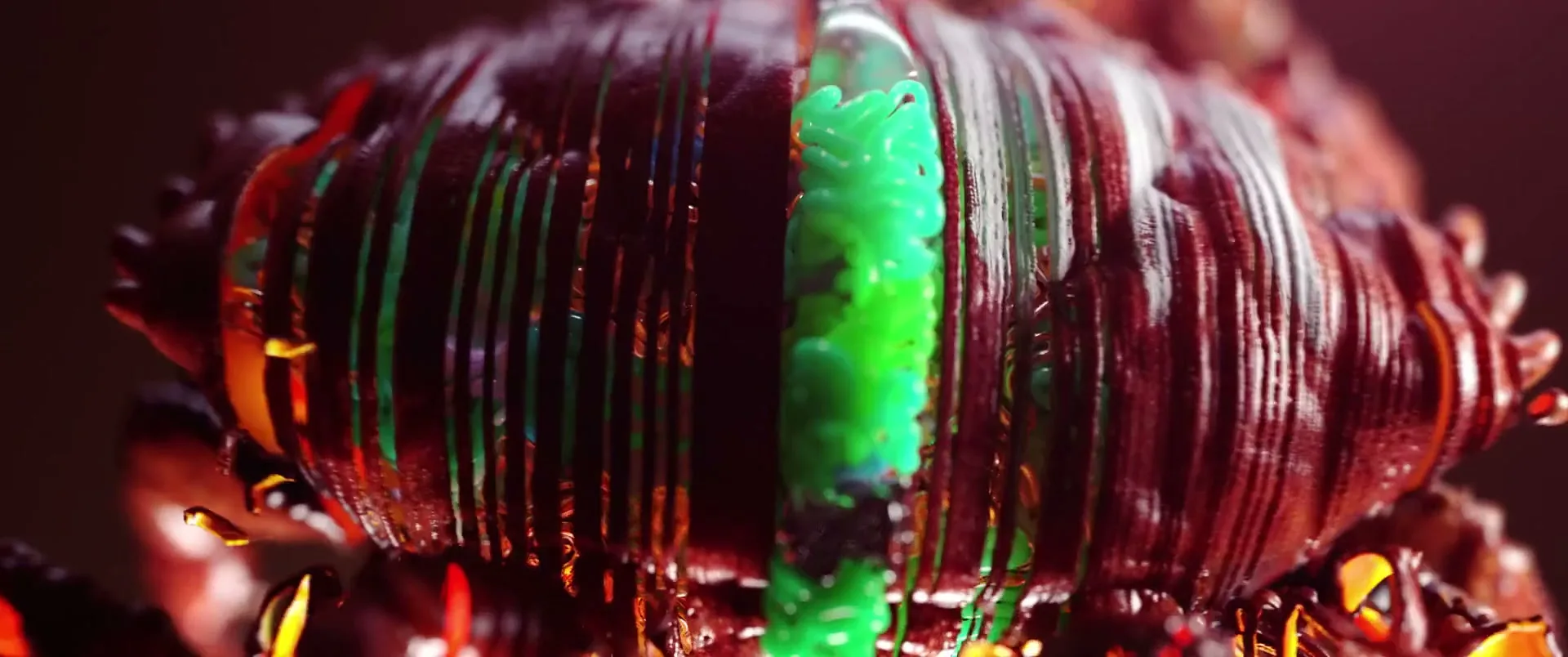 A red crab-like creature is sliced open, revealing a bright green, squiggly interior, in a dark, mysterious setting.
