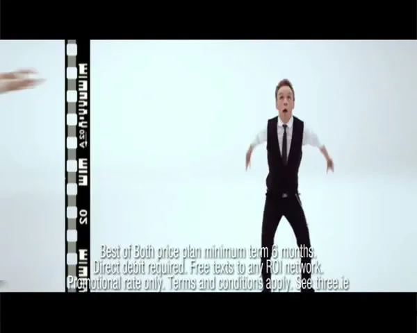 A man in a suit and waistcoat jumps up and down in a white studio, with legal disclaimer text at the bottom of the screen.
