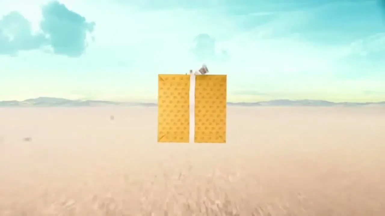A yellow box in a desert landscape opens up to reveal a textured interior, then closes again.