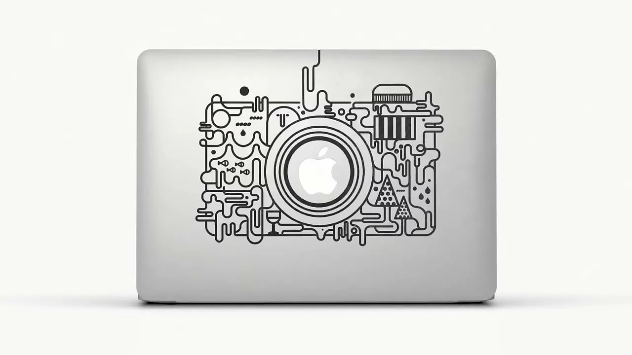A silver MacBook is shown from above, with various stickers appearing and disappearing on its lid, showcasing different designs.