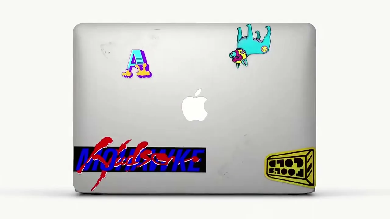 A silver MacBook Pro with various colorful stickers on its lid is shown, with stickers appearing and disappearing in a stop-motion animation.