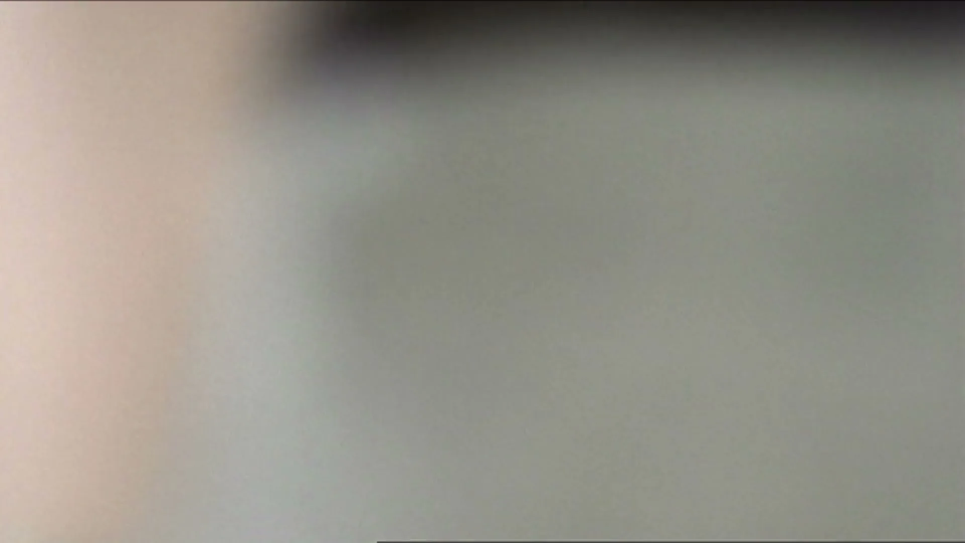 A young boy with brown hair and a white collar shirt looks around with a worried expression in a blurry, bright setting.