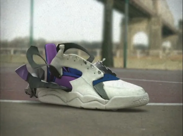 A white, purple, and blue Nike sneaker deconstructs itself on a basketball court with a bridge in the background.