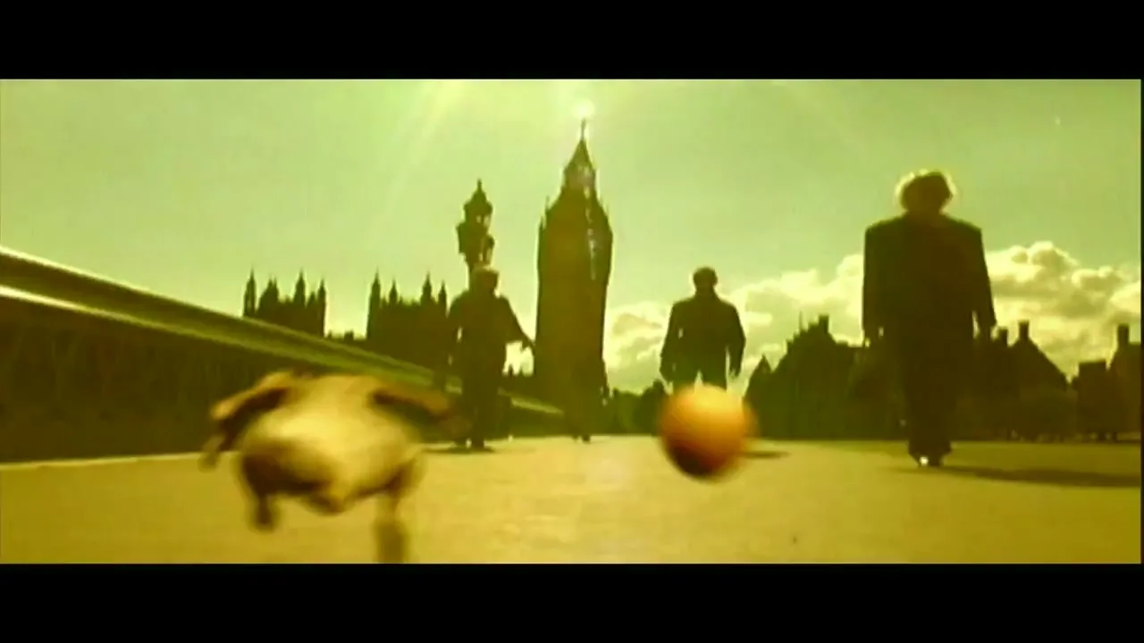 A chicken runs across a bridge in London, with Big Ben in the background, as people walk by and an egg rolls alongside it.