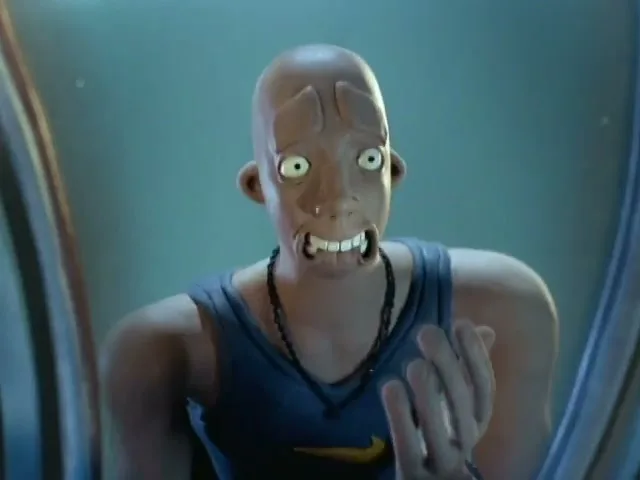 A bald, animated male character in a blue tank top with a Nike logo pulls his face back into place after it was distorted, looking surprised.