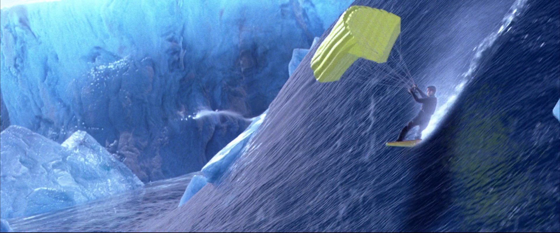 A man kitesurfs vertically against the steep, textured wall of a massive blue glacier. Icy blue crevasses and frozen textures define the surrounding landscape under bright daylight.