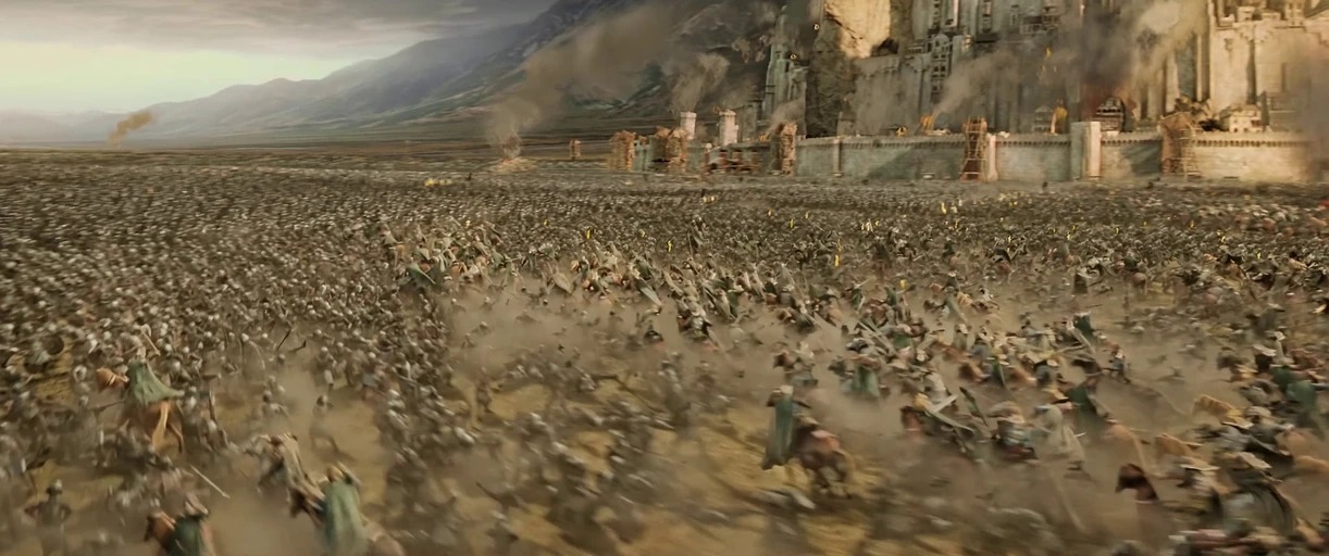 A vast, dusty battlefield stretches before a large stone fortress built into a mountain. Thousands of armored horse-mounted warriors charge across the field in a massive confrontation.