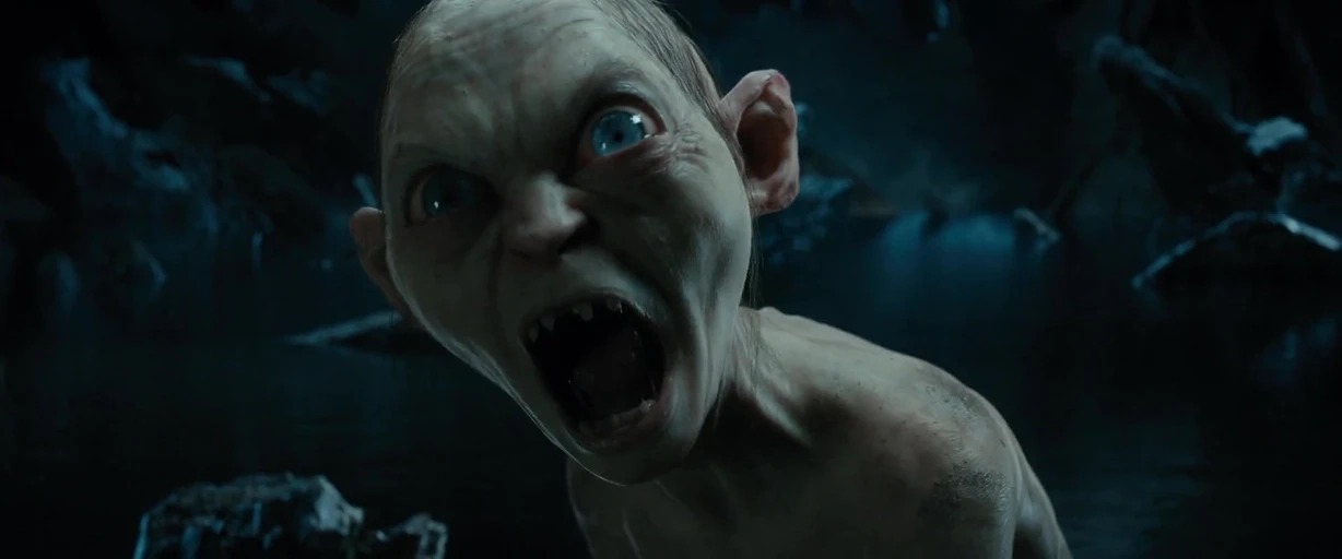 A dark rocky cavern with deep shadows and damp surfaces surrounds the subject. The subject has an open mouth and wide eyes, displaying extreme distress.