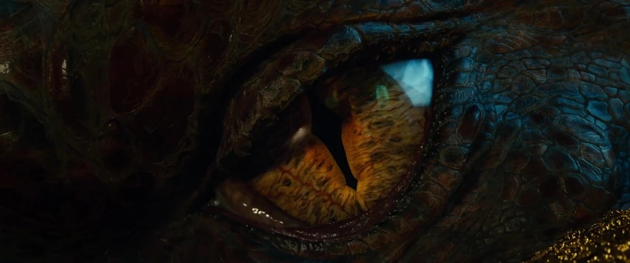 An extreme close-up of a dragon eye reveals intricate scale patterns and a slit pupil. The creature appears to be resting within a dark, dim environment.
