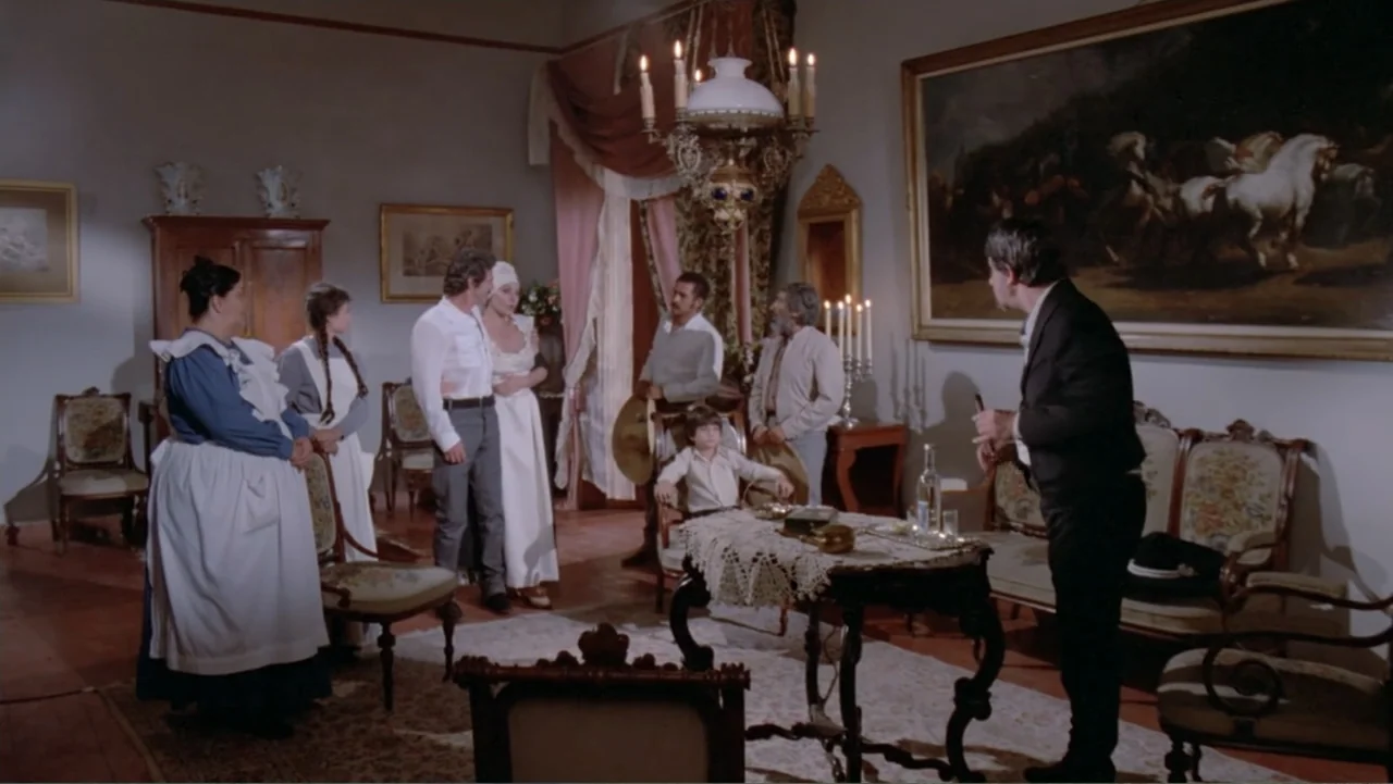 candlelight & firelight example from Toña Machetes: A formal 19th-century drawing room with large oil paintings and period furniture. Several people i