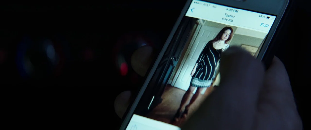 Southbound (2015) movie still: closeup — A dark, blurred environment serves as the background for a smartphone being held close. The screen displays…