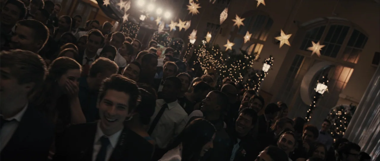 dutch angle shots example from Carrie: A crowded interior ballroom is decorated with hanging illuminated star lanterns and festive lights. Many young