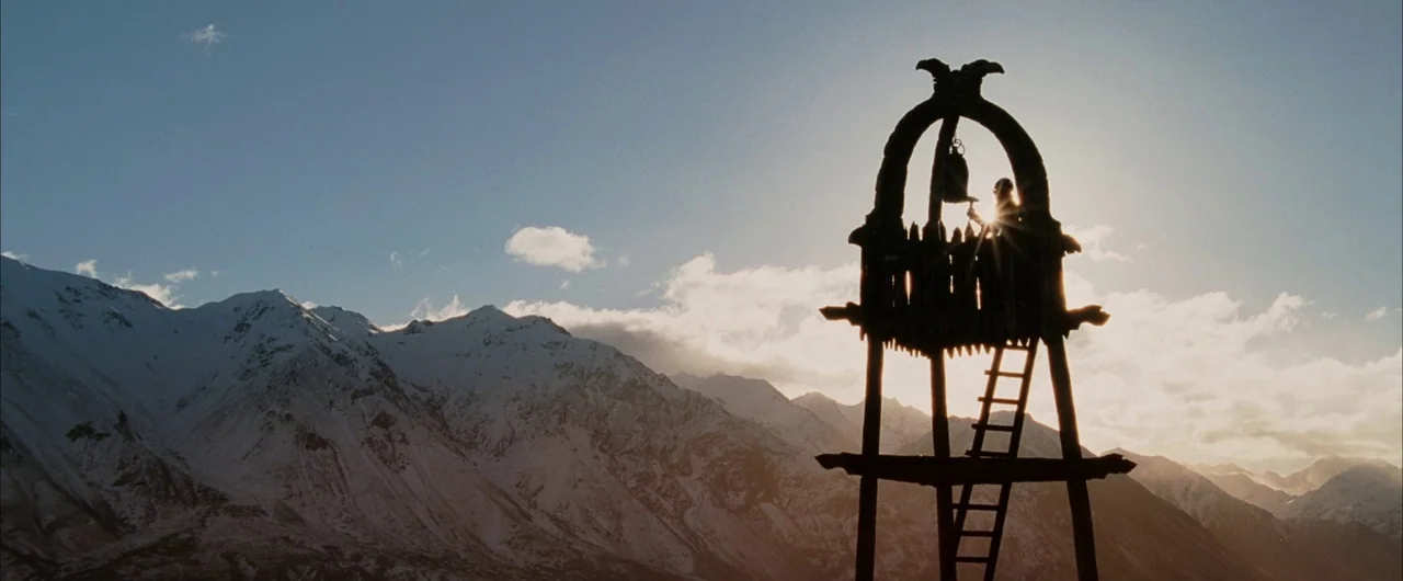 The Lord of The Rings: The Return of the King (2003) movie still: wide — A high, wooden watchtower stands against a backdrop of massive, snow-capped…