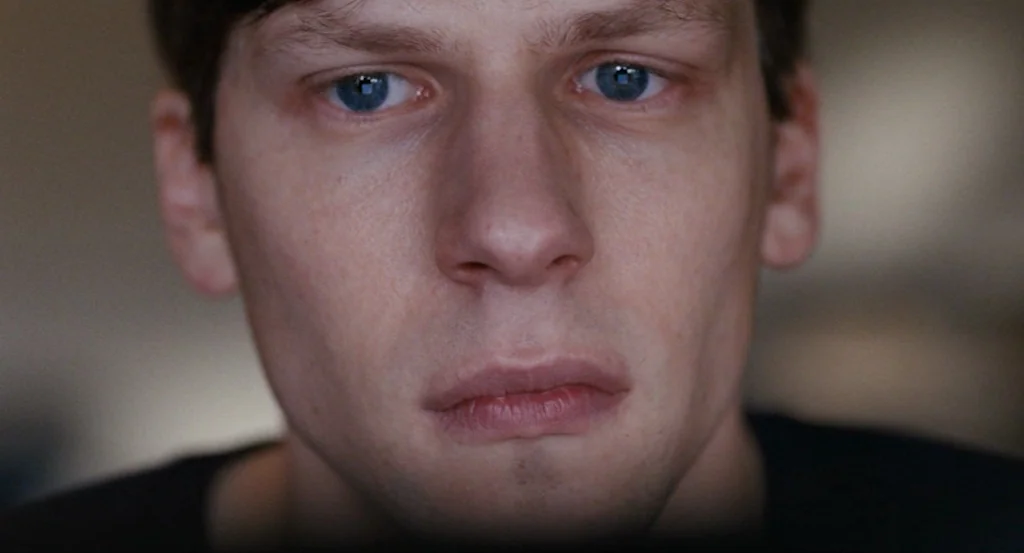 Louder Than Bombs (2015) movie still: closeup — A dimly lit room provides only illumination from a screen reflection on a person. The subject gazes…