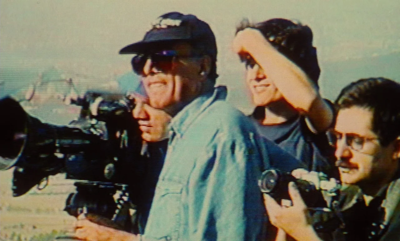 Taste of Cherry (1997) movie still: medium — A group of crew members operates a large professional film camera outdoors. They are surrounded by…