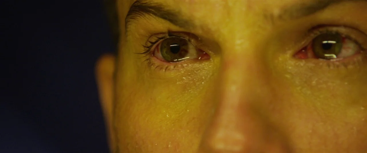 Prometheus (2012) movie still: closeup — A close-up shot focuses on a man's eyes and upper face in extreme detail. The skin appears moist and the…