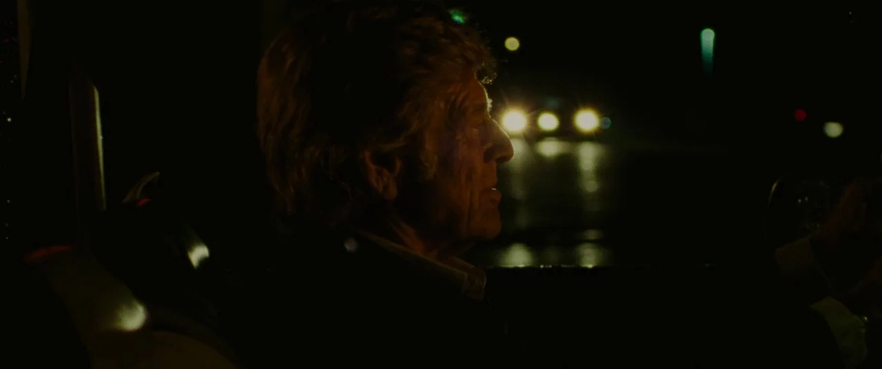 The Old Man & The Gun (2018) movie still: medium — The interior of a vehicle at night with the driver silhouetted against darkness. The driver looks…