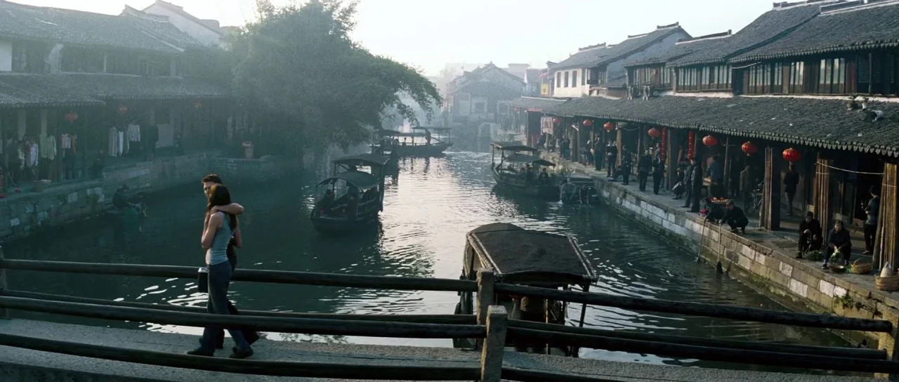 Mission: Impossible III (2006) movie still: wide — A historic canal lined with traditional wooden buildings and red lanterns in morning haze. A…