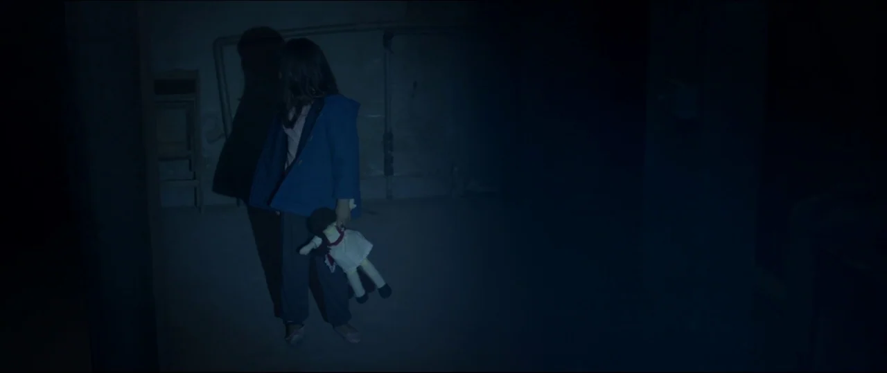 Under The Shadow (2016) movie still: fullbody — A dimly lit basement features concrete walls with exposed piping and a dark corner. A young girl…