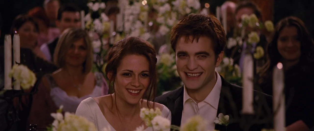 The Twilight Saga: Breaking Dawn – Part 1 (2011) movie still: medium — A dimly lit wedding reception features guests blurred in the background…