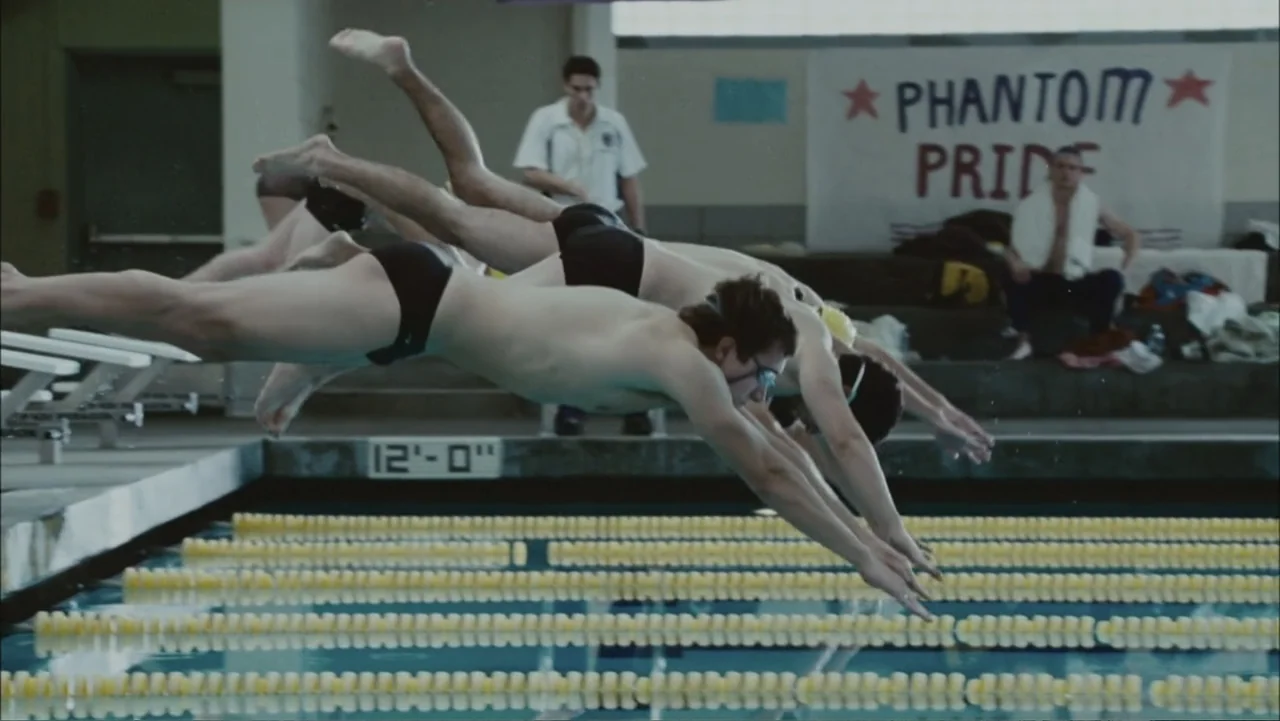 The Stepfather (2009) movie still: medium — An indoor swimming pool with lane dividers and a banner hanging on the wall. Several male teenage…