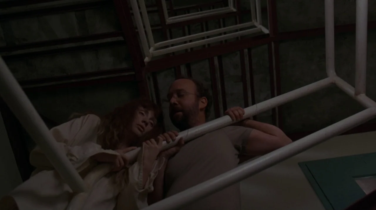 Lady in the Water (2006) movie still: medium — A stairwell with industrial white metal railings visible at an extreme low angle. A man and a woman…