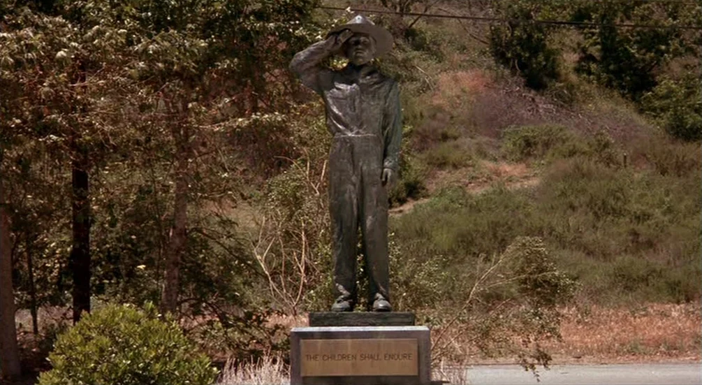 Freddy’s Dead: The Final Nightmare (1991) movie still: fullbody — A bronze statue of a child stands on a stone base in a park. The statue is…