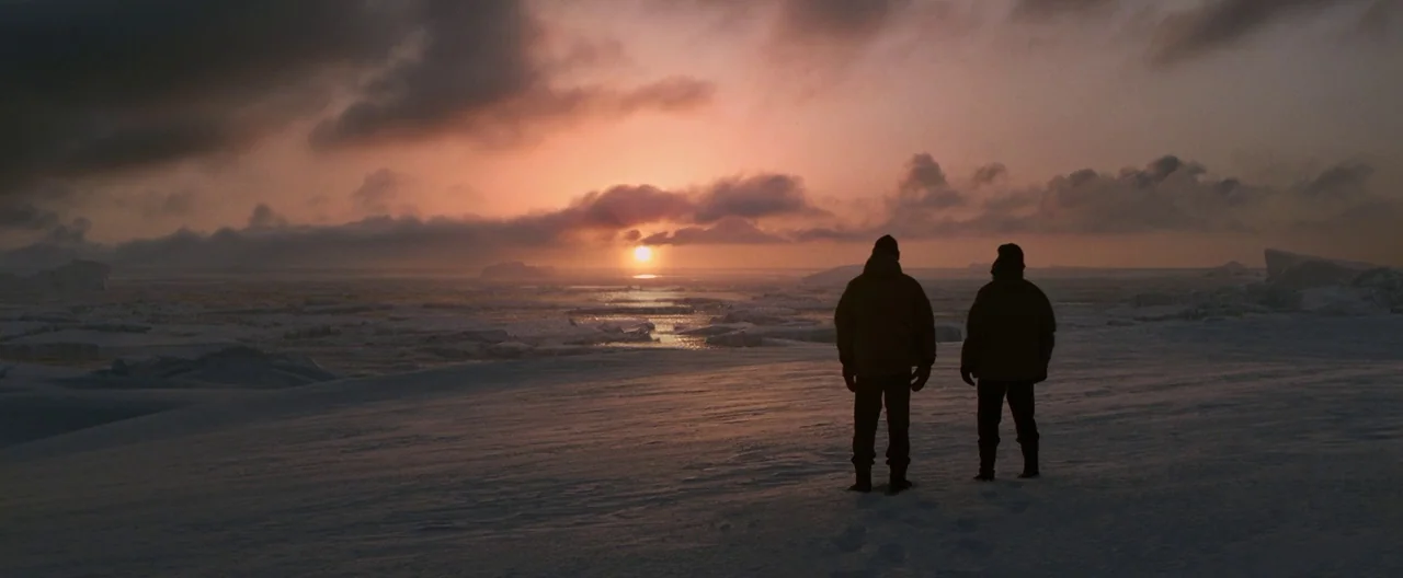 30 Days of Night (2007) movie still: wide — A vast expanse of snowy arctic terrain under a sunset sky with broken ice shelves. Two figures stand in…