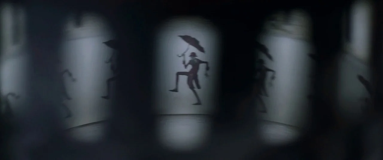 The Conjuring 2 (2016) movie still: closeup — A spinning zoetrope drum displays a sequence of character silhouettes on white paper strips. The…