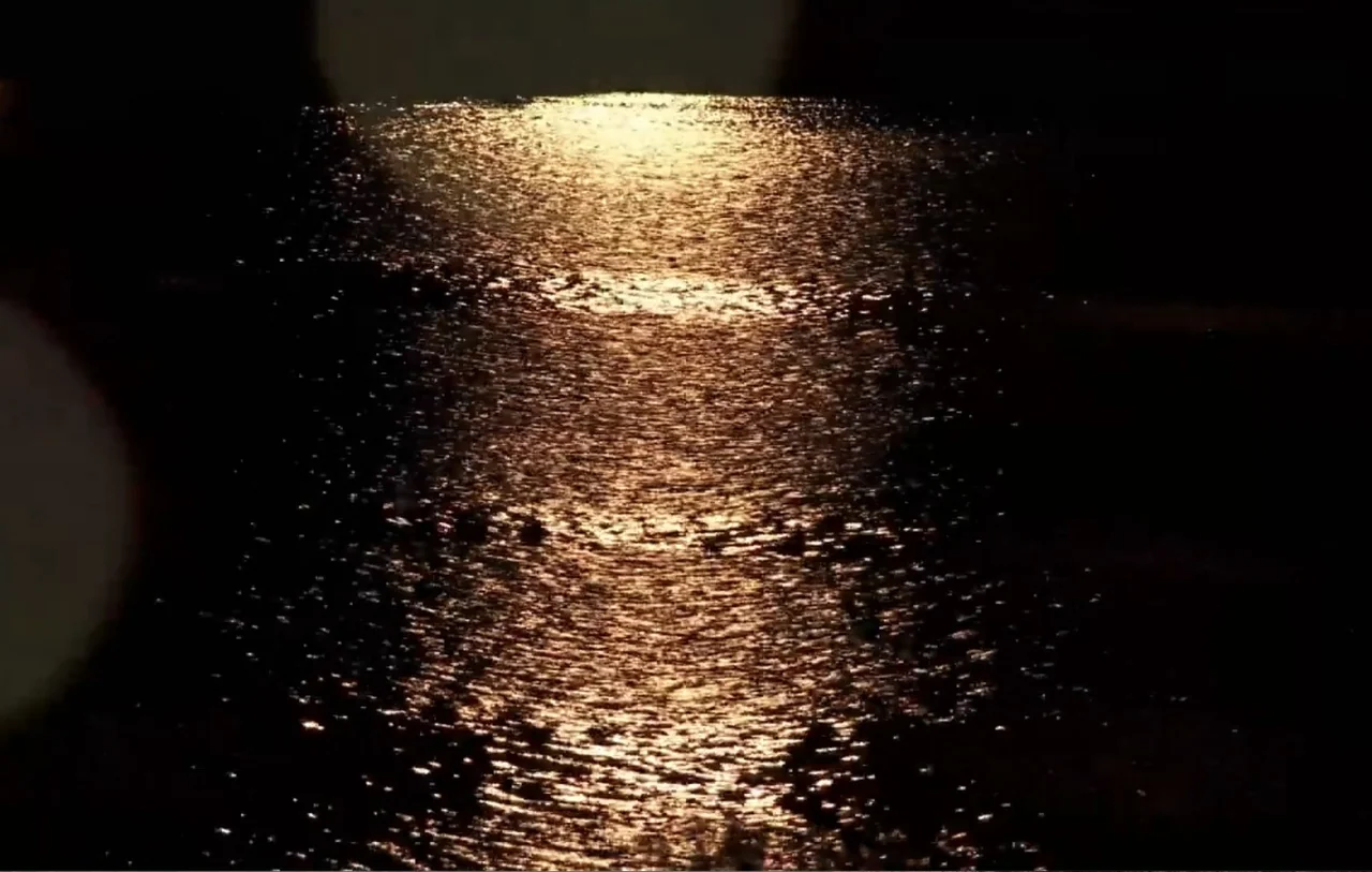 No Place to Hide (1992) movie still: establishing — An expanse of dark, rippling water fills the frame at night. A bright, narrow vertical light…