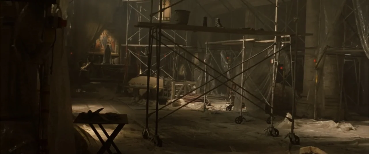 Angels & Demons (2009) movie still: wide — A dimly lit indoor space is undergoing renovation with tall metal scaffolding and plastic sheeting.…