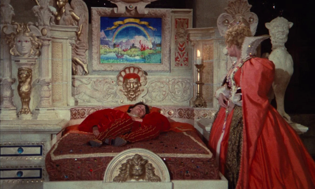 Donkey Skin (1970) movie still: medium — An ornate fantasy bedroom features a large sculpted bed with integrated marble carvings. A man reclines in…