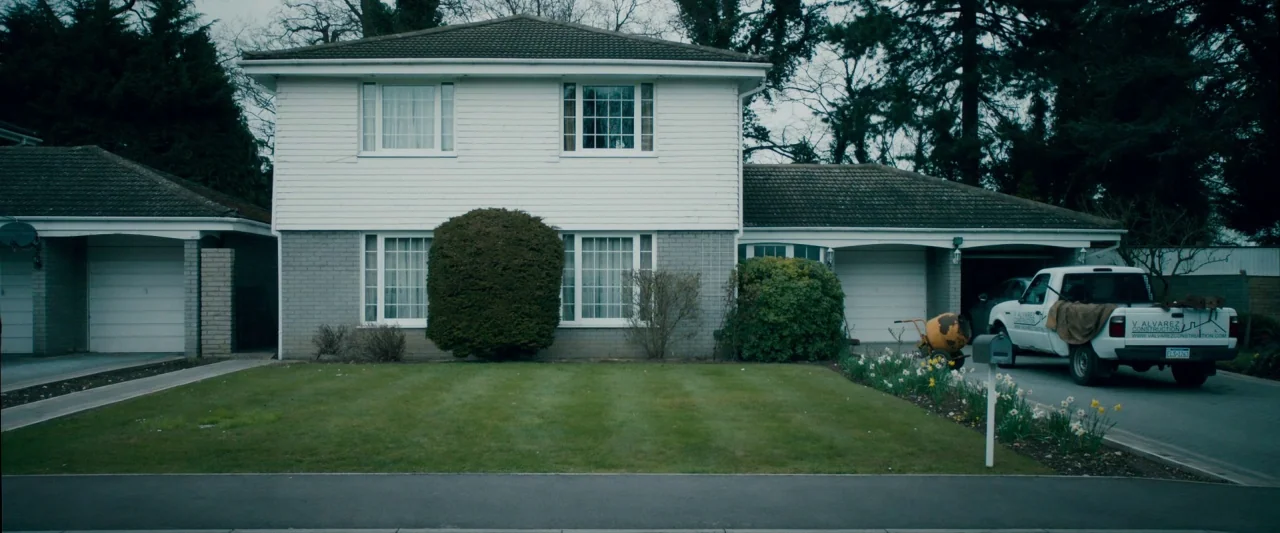The Autopsy of Jane Doe (2016) movie still: wide — A detached suburban two-story house with a white-clad upper level and grey brick base. A white…
