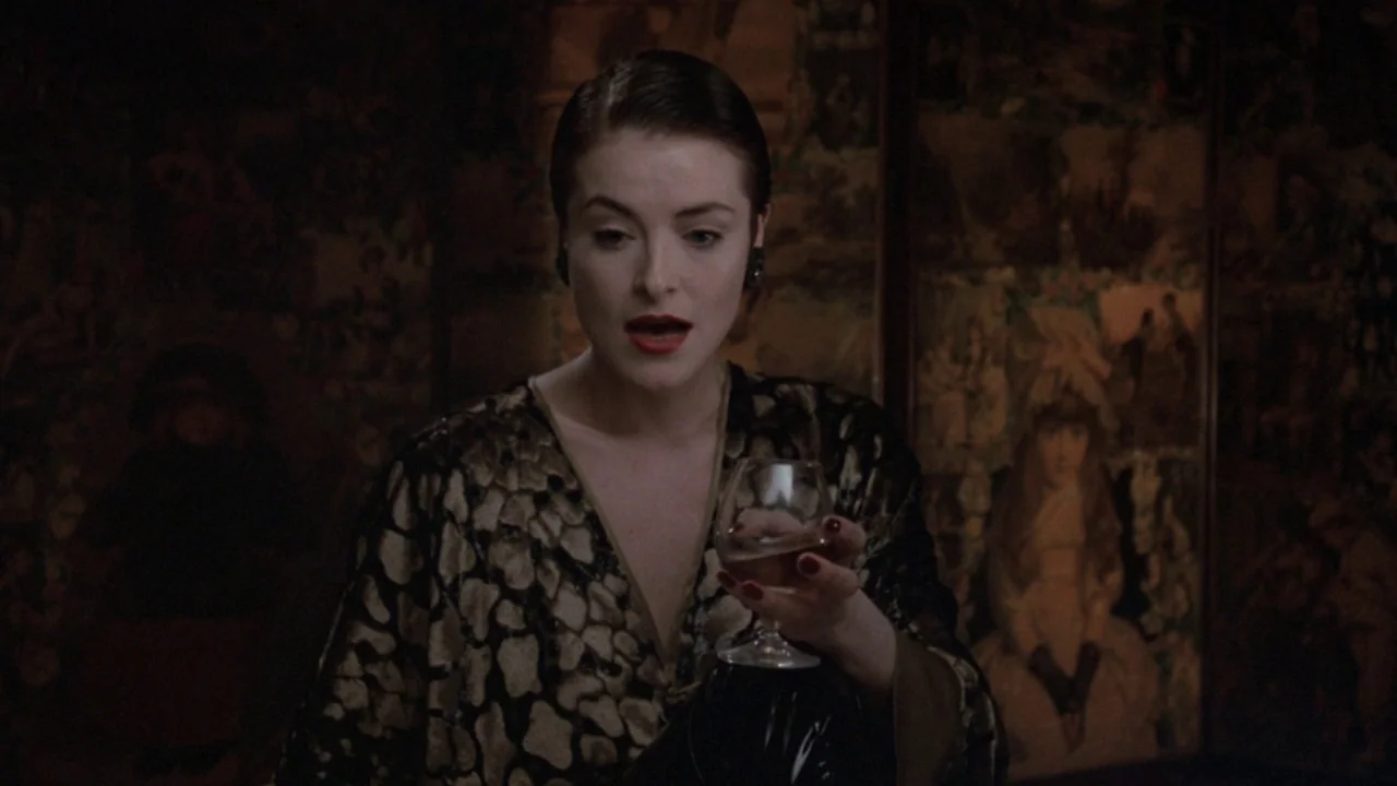 The Lair of the White Worm (1988) movie still: medium — An interior space with dark, patterned wallpaper featuring faded imagery of historical…